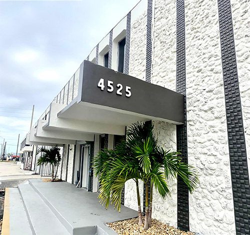 A building with a palm tree in front of it.