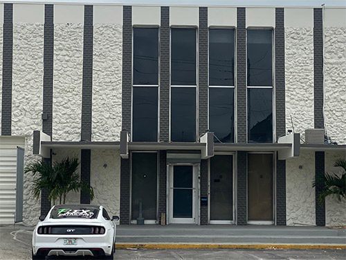 A white car parked in front of an old building.