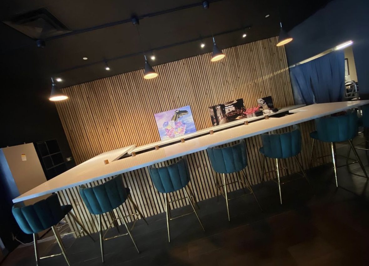 A long table with chairs in front of a wall.