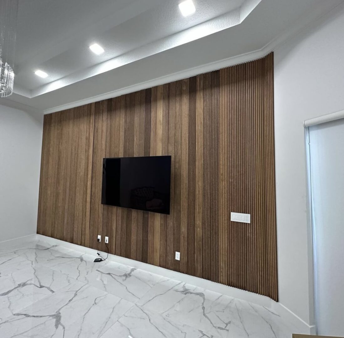 A room with a television and wooden wall